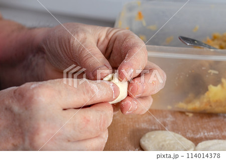 Woman hands are making a damp dumpling. . 114014378