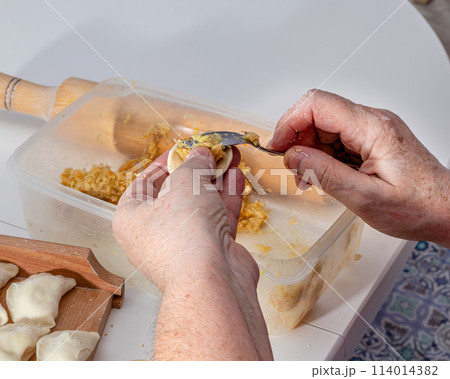 Woman hands are making a damp dumpling.  114014382
