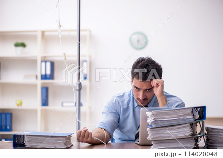 Young male employee suffering at workplace Young male employee suffering at workplace 114020048