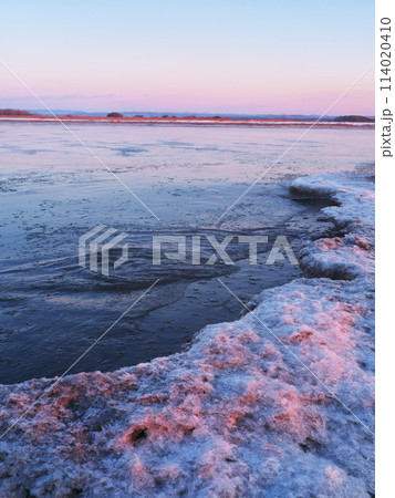 厳冬の北海道十勝川河口　薄氷流れる河面と凍った川岸 114020410