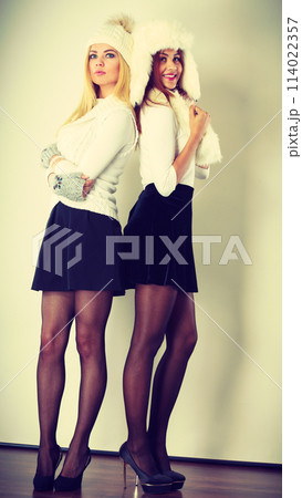 Two ladies in winter white outfit. 114022357