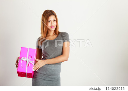 Beautiful mulatto woman with pink gift. Beautiful mulatto woman with pink gift. 114022913