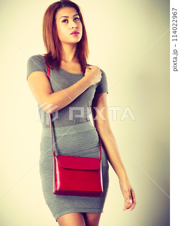 Mulatto girl gray wear with red handbag 114022967