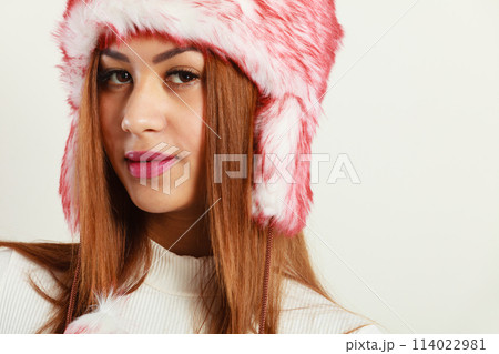Mulatto woman wearing winter fur cap 114022981