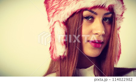 Mulatto woman wearing winter fur cap 114022982