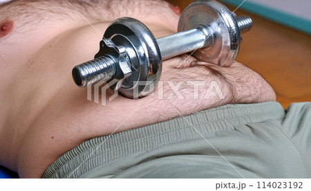 Close-up of a Dumbbell on a Fat Male Belly in the Gym - Generative Ai 114023192