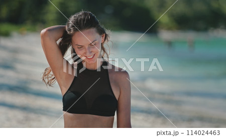 Beautiful happy woman walk tropical beach. Caucasian girl in bikini enjoy nature landscape with blue sea and white sand shore. Relax on tropical island, nature summer scene. Travel, tourism, holiday Beautiful happy woman walk tropical beach. Caucasian girl in bikini enjoy nature landscape with blue sea and white sand shore. Relax on tropical island, nature summer scene. Travel, tourism, holiday 114024463