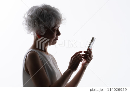 スマホを操作するシニア女性　シルエット  114026929