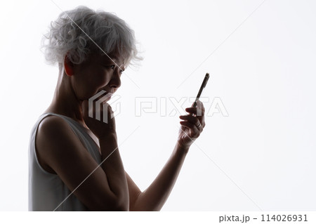 スマホを操作するシニア女性　シルエット  114026931