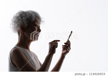 スマホを操作するシニア女性　シルエット  114026933