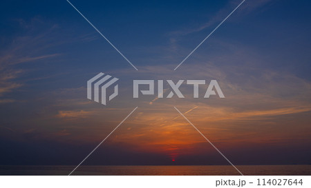 夕方の空に沈む夕陽と流れゆく雲 夕方の空に沈む夕陽と流れゆく雲 114027644