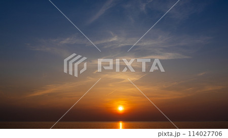 夕方の空に沈む夕陽と流れゆく雲 114027706