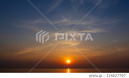夕方の空に沈む夕陽と流れゆく雲 夕方の空に沈む夕陽と流れゆく雲 114027707