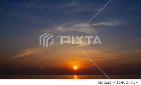 夕方の空に沈む夕陽と流れゆく雲 夕方の空に沈む夕陽と流れゆく雲 114027717