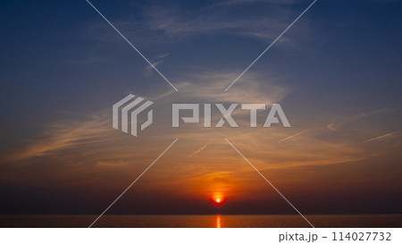 夕方の空に沈む夕陽と流れゆく雲 夕方の空に沈む夕陽と流れゆく雲 114027732