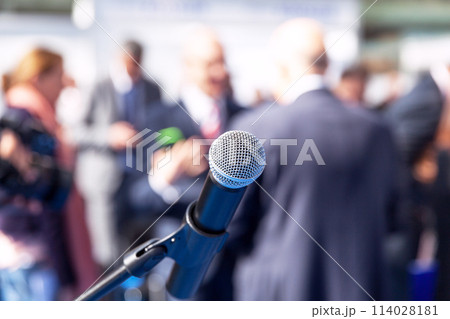 Microphone in focus against blurred people Microphone in focus against blurred people 114028181