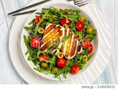 salad with grilled halloumi greek cheese in bowl 114028415