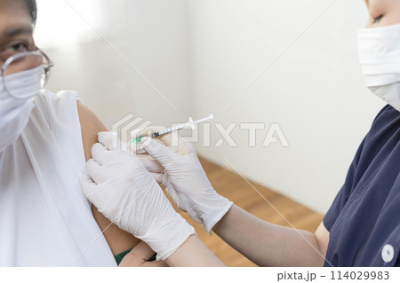 Elderly Asian woman getting coronavirus vaccine by nurse. Medical worker prepare syringe. 114029983