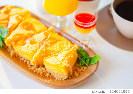 Baked vanilla and tropical flavour cheesecake swirled with passion fruit sauce on a digestive biscuit crumb 114031096