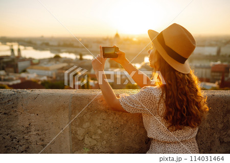 Travel in Europe. Young woman enjoys sunrise. The concept of travel, tourism, vacation and freedom. 114031464