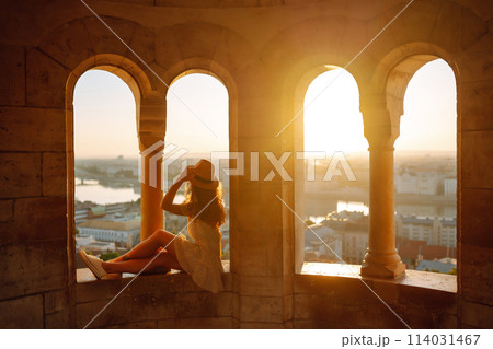 Young female tourist enjoys the view of the city at sunset. Travel and tourism concept. Young female tourist enjoys the view of the city at sunset. Travel and tourism concept. 114031467