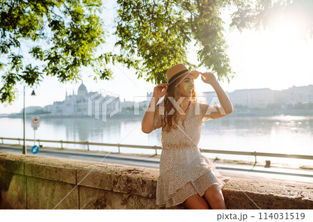 A beautiful young woman walks on the embankment. Tourism relax, youth, nature. 114031519