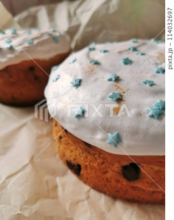 Easter Christian cake with chocolate filling with white icing decorated with blue stars and golden candurin on craft paper	 114032697