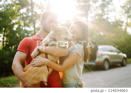 Young couple together with their beloved pet on walk. Domestic dog concept. Active lifestyle concept Young couple together with their beloved pet on walk. Domestic dog concept. Active lifestyle concept 114034063
