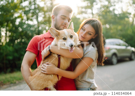 Young couple together with their beloved pet on walk. Domestic dog concept. Active lifestyle concept 114034064