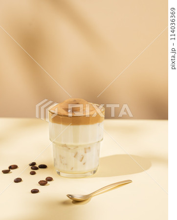 Vegan dalgona coffee. Whipped instant iced coffee with soy milk in a glass on yellow background 114036369