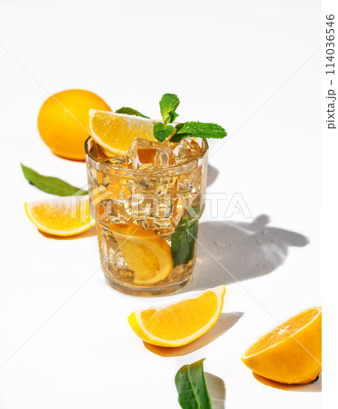 Iced tea with lemon and mint on white background with a shadow and citrus fruits. 114036546