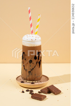 Cold chocolate coffee drink or milkshake with whipped cream in a tall glass  114036632