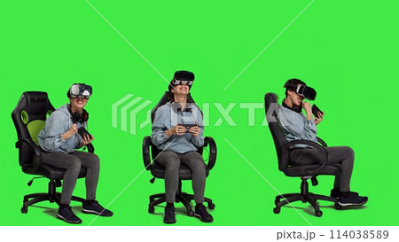 Happy gamer winning video games tournament with vr glasses, playing mobile gaming championship using her smartphone and virtual reality interactive headset. Greenscreen backdrop. Camera A. 114038589