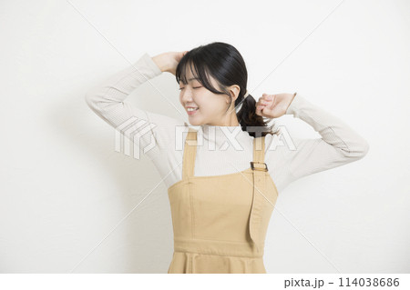 背伸びをする若い女性 背伸びをする若い女性 114038686