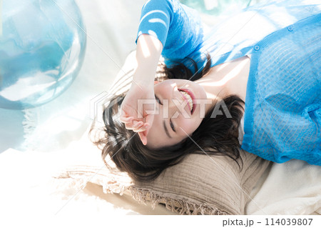 眩しい夏の日差しで寝転がる美しい女性 海や夏の日焼けやUVの美容の透明感のあるイメージなどにも 俯瞰 眩しい夏の日差しで寝転がる美しい女性 海や夏の日焼けやUVの美容の透明感のあるイメージなどにも 俯瞰 114039807