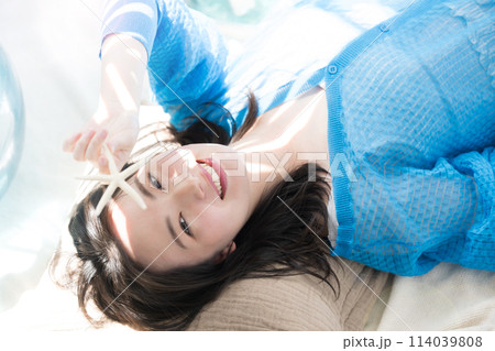 眩しい夏の日差しで寝転がる美しい女性 海や夏の日焼けやUVの美容の透明感イメージ カメラ目線 眩しい夏の日差しで寝転がる美しい女性 海や夏の日焼けやUVの美容の透明感イメージ カメラ目線 114039808