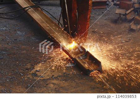 A worker cuts an iron rail with an autogen. A worker cuts an iron rail with an autogen. 114039853