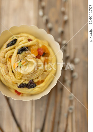raw kraffin kulich with candied fruit on wooden table with sprigs of willow top view raw kraffin kulich with candied fruit on wooden table with sprigs of willow top view 114041707