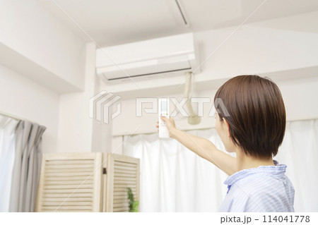 エアコンのリモコンを使う女性 114041778