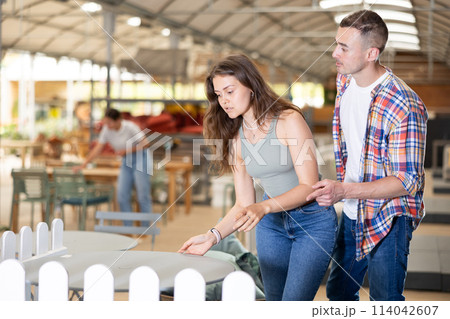 Spouses buyer choose table desk in garden furniture store showroom 114042607