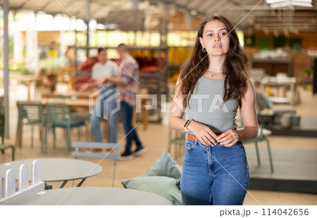 Girl buyer choose table desk in garden furniture store showroom 114042656
