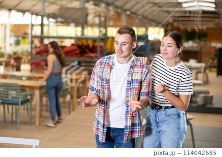 Spouses look for something in furniture store, searching for perfect item to complete patio 114042685