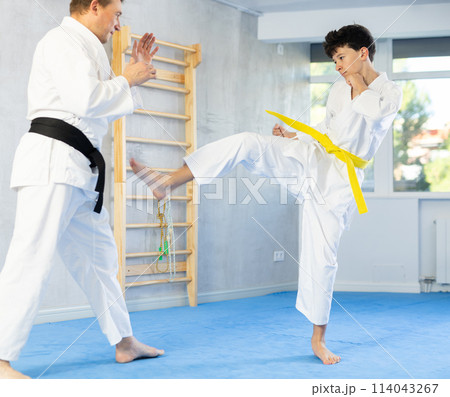 Man and teenage boy training karate fight 114043267