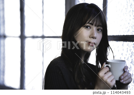 窓際でコーヒーを飲む若い女性 114043493