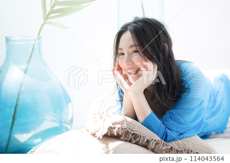 うつ伏せで頬杖をする美しい女性 夏の日差しで寝転がる 海や夏の日焼けやUVの美容イメージ うつ伏せで頬杖をする美しい女性 夏の日差しで寝転がる 海や夏の日焼けやUVの美容イメージ 114043564