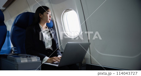 Beautiful Asian businesswoman working with laptop in aeroplane. working, travel, business concept Beautiful Asian businesswoman working with laptop in aeroplane. working, travel, business concept 114043727