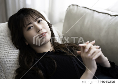 ソファに寝転んでくつろぐ若い女性 ソファに寝転んでくつろぐ若い女性 114043836