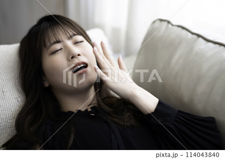ソファに寝転んでくつろぐ若い女性 ソファに寝転んでくつろぐ若い女性 114043840