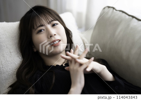 ソファに寝転んでくつろぐ若い女性 ソファに寝転んでくつろぐ若い女性 114043843