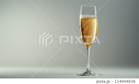 A glass of champagne is sitting on a table 114044636